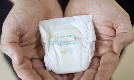 Pampers Preemie Protection luier liggend in grote handen