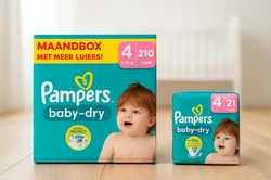 Pampers Baby-Dry maandbox naast een los pak Pampers Baby-Dry maat 4 maandbox met 210 luiers naast een los pak met 21 luiers op de vloer van een babykamer.