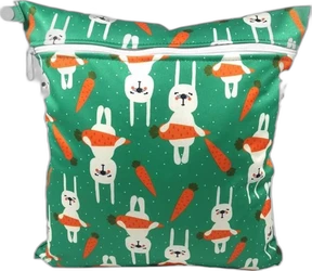 Groene wetbag met konijnen- en wortelprint Groene wetbag met witte rits en print van witte konijnen en oranje wortels op een gestippelde achtergrond.