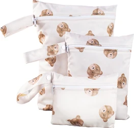 Drie witte wetbags met bruine beertjesprint, ritssluiting en polsbandjes met drukknopen.