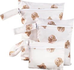 Drie witte wetbags met bruine beertjesprint, ritssluiting en polsbandjes met drukknopen.