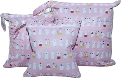 Drie roze wetbags met rits en witte berenprint tegen zwarte achtergrond