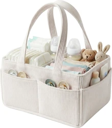 Crème corduroy luiermand met handgrepen, gevuld met luiers, flessen, speentjes, kleding en knuffels.