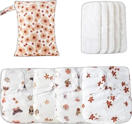 Set wasbare stoffen luiers met botanische prints, witte inleggers en bloemenetui op zwarte achtergrond