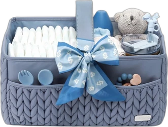 Blauwe gewatteerde luiercaddy met grote strik, luiers, knuffel en babyaccessoires in vakken