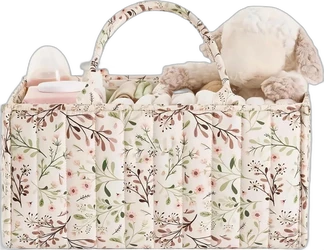 Crème gewatteerde luiercaddy met bloemenprint, handvatten en vakken gevuld met babyspullen en knuffel