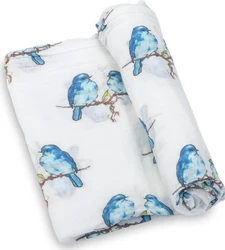 Hydrofiele doek met blauwe vogelprint Witte hydrofiele doek met blauwe vogels op takken, gevouwen en deels opgerold
