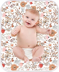 Lachende baby op een rechthoekige verschoonmat met roze en bruine bloemenprint en lichte rand