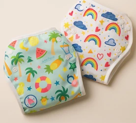 Twee herbruikbare luiers met zomerprints een mint met palmwatermeloen en een wit met regenbogen