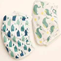 Twee herbruikbare luiers met walvisprints in groen en blauw op een lichte achtergrond