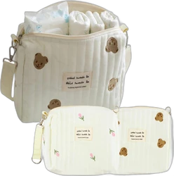 Gewatteerde 3-delige luiertassenset all about baby beige Beige gewatteerde luiertassenset bestaande uit grote luiertas en twee kleinere etuis met beren en bloemetjes