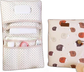 Opgevouwen en open beige luiertas organizer met kleine groene stippen en print van gekleurde egelachtige beertjes