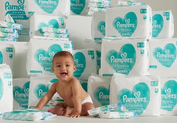baby met heel veel pampers verpakkingen