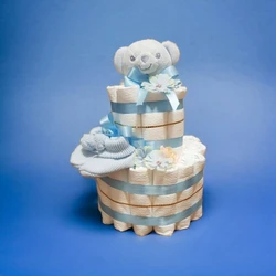 Blauwe luiertaart van luiers met knuffelbeertje, babysokjes, linten en bloemen op blauwe achtergrond